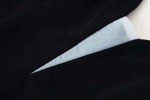 Detailed macro view of black textured fabric with breathable mesh lining of the dress