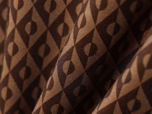 Vue détaillée d'un tissu en toile épaisse avec un motif géométrique vintage en marron foncé