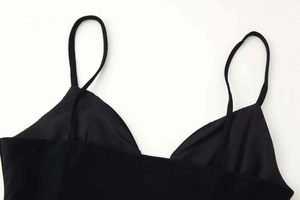 Detailed close-up of a black V-neck sleeveless top with delicate spaghetti straps