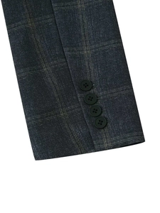 Detail of dark grey plaid blazer sleeve with four matte buttons and Prince of Wales check