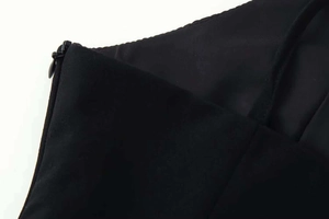 Detail of invisible zipper and fine stitching on a black V-neck summer dress