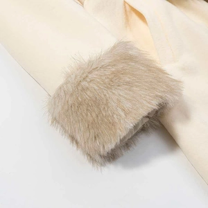 Detail of elegant beige wool coat sleeve featuring a plush faux fur cuff trim