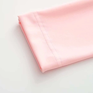 Close-up of double-needle reinforced stitching on pink knit yoga jumpsuit sleeve