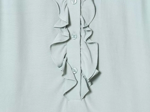 Close-up of light blue chiffon shirt featuring ruffled trim and matching buttons detail