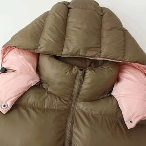 Minimalist olive green and pink puffer jacket with adjustable hood and metal zipper detail