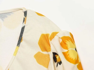 Detail of ribbed knit fabric with yellow floral print and elegant puff sleeve seam