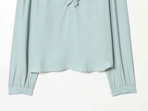 Detailed view of the elegant light blue long sleeve blouse fabric and ruffled cuff design