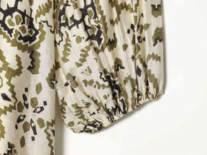 Détail du tissu tissé à imprimé floral ethnique et poignets élastiques sur manches lanternes