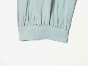 Detail shot of light green ruffled cuff featuring textured fabric and neat stitching