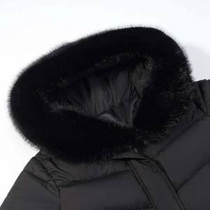 Close-up of winter coat with luxurious black faux fur trim hood and quilted satin texture
