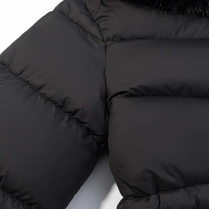 Detail of black hooded winter coat with faux fur collar and quilted texture