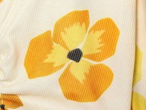 Detailed close-up of vertical ribbed fabric with vibrant orange floral digital print