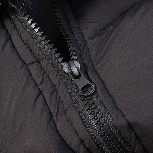 Detail of black quilted puffer coat with high-quality metal zipper and faux fur collar