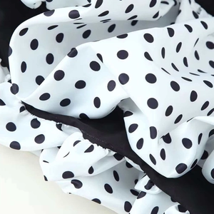 Chic V-neck sleeveless dress with black and white polka dots and tiered ruffle details