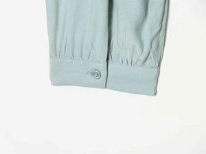 Detailed macro view of the ruffled cuff with button on a light sage green blouse