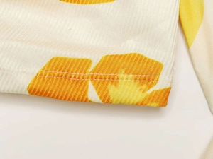 Detail view of ribbed cotton fabric with yellow floral print and double-stitch seams