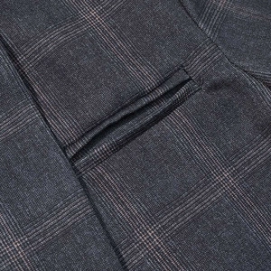 Close-up of the grey plaid suit fabric showing a welt pocket and detailed stitching