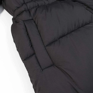 Detail of black quilted puffer jacket featuring diagonal stitching and side pocket design
