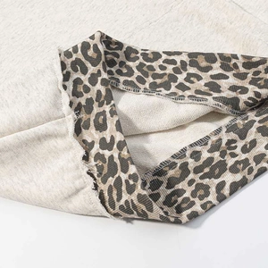 Close-up of leopard print lining and raw edge detail on oat knit hoodie sweatshirt