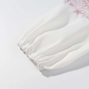 Close-up of elastic ruffled cuffs on a pink floral print dress with chiffon texture