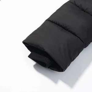 Detail of windproof knit ribbed cuffs on long black quilted winter puffer coat