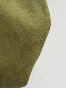 Close-up of olive green suede fabric showing fine fiber texture and matte finish