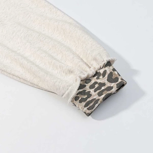 Macro shot of oatmeal grey hoodie sleeve with leopard print ribbed cuffs details