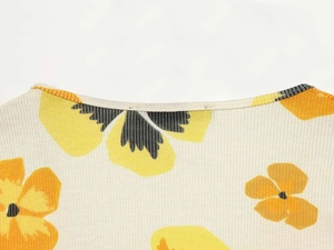 Close-up of crew neckline and floral print texture on the white long sleeve dress