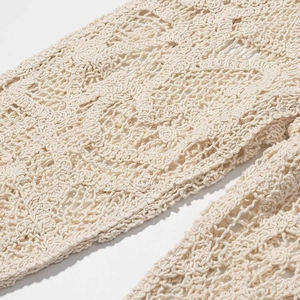 Gros plan détaillé du motif floral évidé en tricot au crochet sur tissu beige