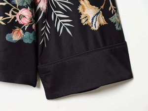 Detailed close-up of floral print satin fabric on the sleeve with neat stitching