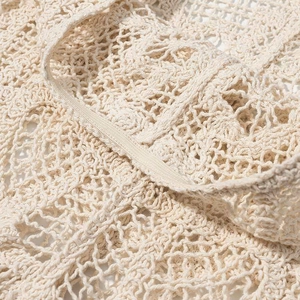 Gros plan détaillé montrant la texture complexe du crochet et le motif ajouré beige