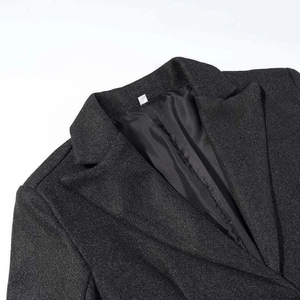 Detailed view of the dark grey wool coat featuring notch lapels and textured fabric