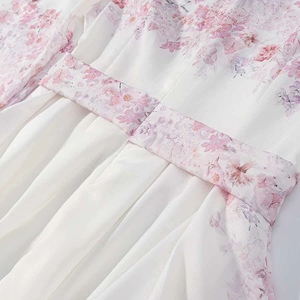 Detailed macro view of the elastic waist tie and pink floral print on white chiffon dress