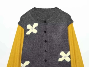 Detail of grey and yellow knit cardigan with floral patterns and pearl embellishments
