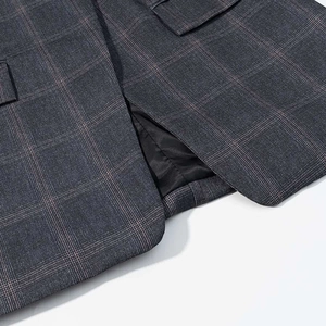 Detail of grey and pink checkered blazer featuring a back slit and smooth black silk lining