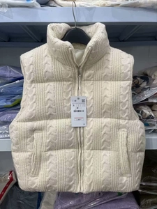 Detail of off-white cable-knit vest with front zipper and stand-up ribbed collar