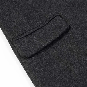Detail of classic flap pocket on dark grey wool coat with high-quality stitching texture