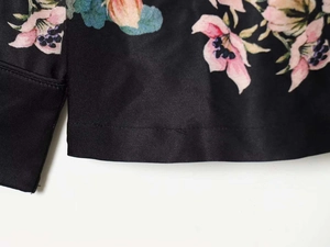 Close-up of floral print satin fabric detail with neat stitching and smooth texture