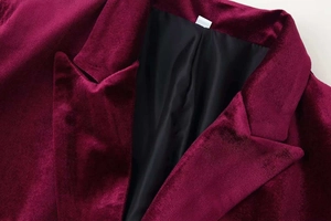 Detailed close-up of premium burgundy velvet blazer featuring lapel and smooth black lining