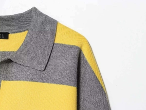 Detail view of the yellow and grey striped knit sweater showing the polo collar and fabric