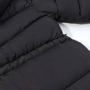 Detail of black windproof winter coat with waist slimming pleats and horizontal quilting