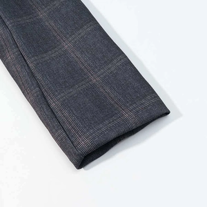 Close-up of the grey plaid suit sleeve showing fine fabric texture and neat stitching detail