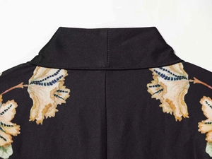Detailed view of the symmetrical floral print and neckline on the black satin kimono top