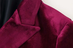 Detailed macro view of burgundy velvet blazer lapels showing premium soft fabric texture