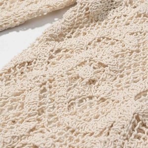 Détail de la dentelle au crochet et de la texture ajourée sur ce pantalon crème