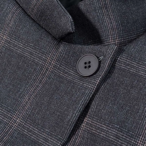 Macro shot of dark grey plaid suit fabric with fine texture and high-quality resin button