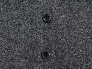 Close-up of grey wool fabric texture featuring two classic black four-hole buttons
