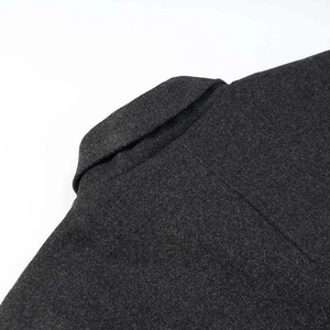 Macro detail of dark grey wool blend fabric texture and collar stitching on long coat