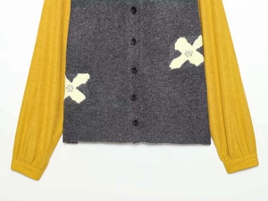 Detail of color block knit cardigan with floral embroidery and sequin accents