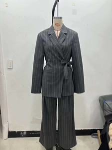 Detail of grey pinstripe blazer suit with waist tie belt on a mannequin display